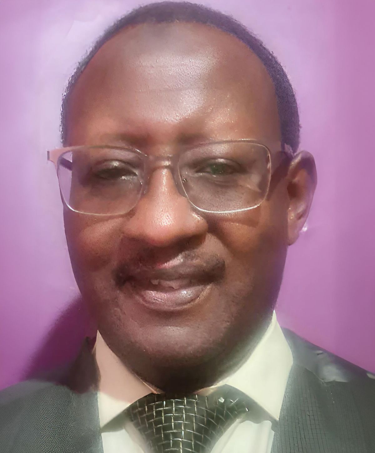 Man in formal attire against purple background.