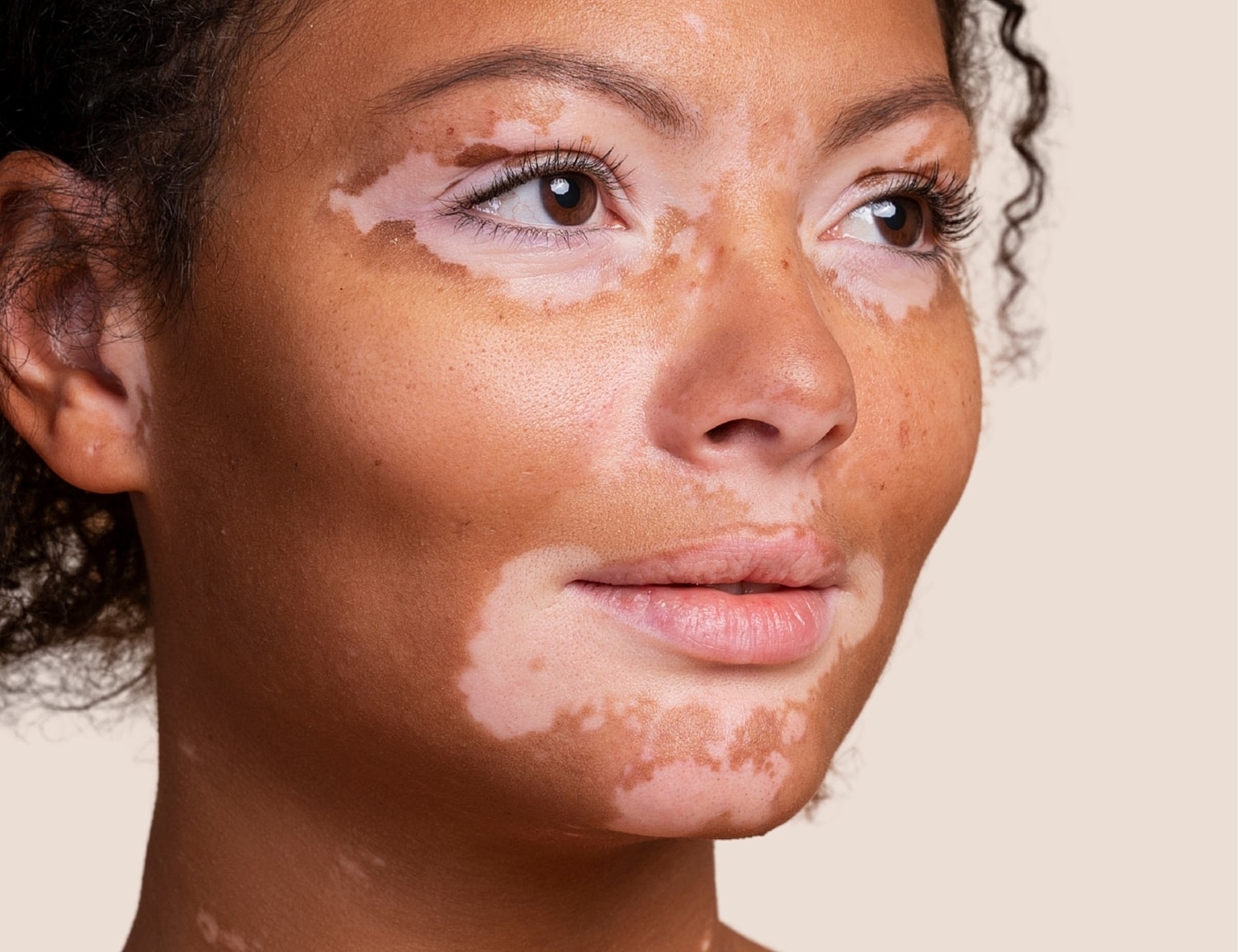 Smiling young woman with curly hair.