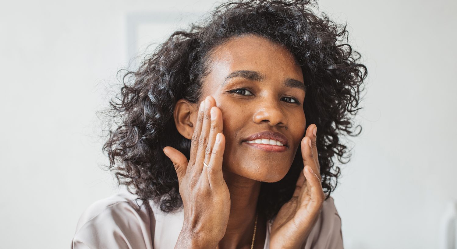Woman applying skincare on her face.