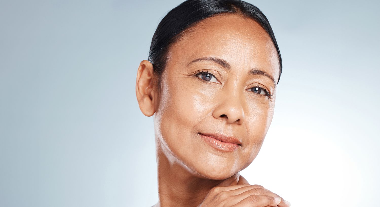 Smiling woman with smooth skin and elegant posture.