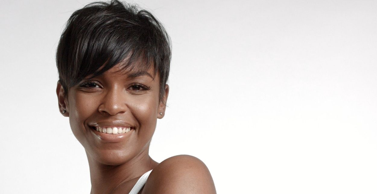 Smiling woman with short hair against white background.